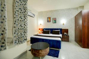 a hotel room with a bed and a table at Hotel O Riddhinn6 in Jalandhar