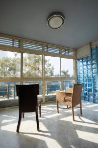 a room with two chairs and a table and windows at Nilotique in Cairo