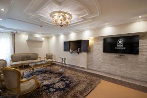a living room with a couch and a tv on a wall at Nilotique in Cairo
