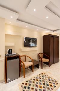 a room with two chairs and a desk and a tv at Nilotique in Cairo +13 photos