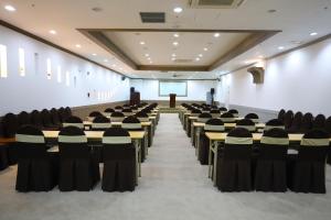 a lecture hall with tables and chairs and a podium at Incheon Freshia Hotel in Incheon