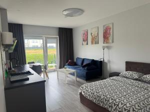 a bedroom with a bed and a desk and a couch at K-Town - Apartments ViaBaltic Kaunas in Kaunas