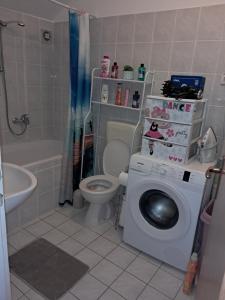 a bathroom with a toilet and a washing machine at Apartman Antonio in Gospić