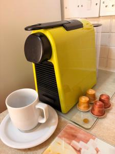 a yellow coffee maker and a cup on a counter at VIP Resort Apartment on Makenzie Beach in Larnaca