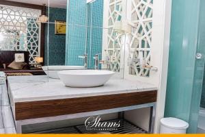 a bathroom with a sink and a mirror at Shams Albasra Hotel in Al Başrah +22 photos