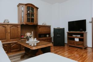 a living room with a tv and a table with candles at Apartman Antonio in Gospić
