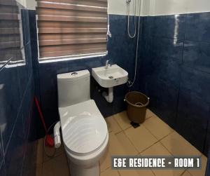 a bathroom with a white toilet and a sink at E&E Residence in Locsin