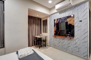 a room with a table and a tv on a wall at Hotel Samarth Elite Baner - Indian Guests Only in Pune