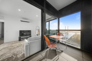 a bedroom with a bed and a table and chairs at River View 1BR Docklands Apartment sleeps 3 in Melbourne