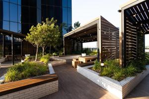 a building with a patio with benches and plants at River View 1BR Docklands Apartment sleeps 3 in Melbourne