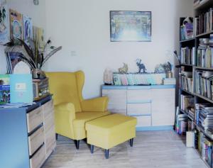 a living room with a yellow chair and a dresser at Zakątek Transformacji in Łużna