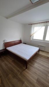 a large bed in a room with a window at Pension Úsvit in Podkopná Lhota