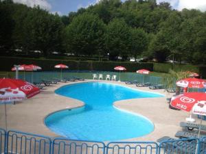 a large swimming pool with umbrellas and chairs at Chambres les 4 saisons in Oust