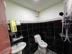 a bathroom with a toilet and a sink at Papalu Villa in Kuala Penyu