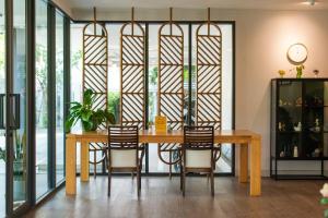 a dining room with a wooden table and chairs at BB House Rangsit บีบี เฮ้าส์ รังสิต in Ban Talat Rangsit
