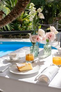 a table with a plate of cake and a vase of flowers at Reginna Palace Hotel in Maiori