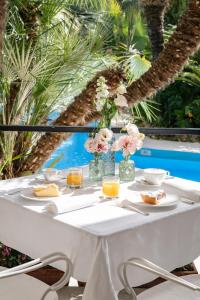 a white table with plates of food and flowers on it at Reginna Palace Hotel in Maiori