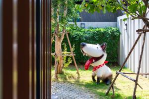 a large stuffed dog sitting in the grass at BB House Rangsit บีบี เฮ้าส์ รังสิต in Ban Talat Rangsit