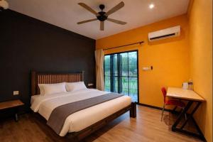 a bedroom with a bed with a ceiling fan and a window at Papalu Villa in Kuala Penyu +9 photos