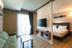 a hotel room with a bed and a tv at BB House Rangsit บีบี เฮ้าส์ รังสิต in Ban Talat Rangsit