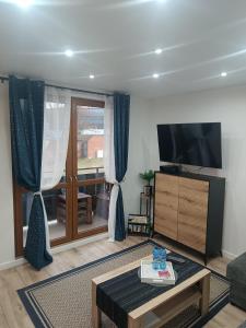 a living room with a tv and a coffee table at Cosy Space Apartment in Tychy