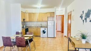 a kitchen with a table and chairs and a dining room at Apartamentos Ajabo Adeje in Adeje
