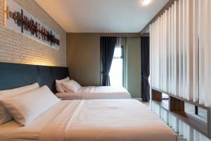 a hotel room with two beds and a staircase at BB House Rangsit บีบี เฮ้าส์ รังสิต in Ban Talat Rangsit +3 photos