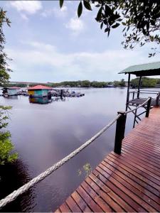 a dock with a bench and boats on the water at Papalu Villa in Kuala Penyu
