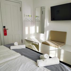 a bedroom with two beds and a mirror and a chair at Hotel Brandenburger Dom in Brandenburg an der Havel