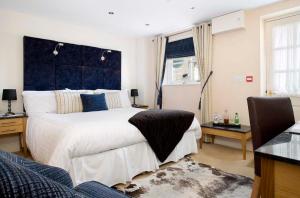 a bedroom with a large bed with a blue headboard at Redesdale Arms Hotel in Moreton in Marsh