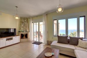 a living room with a couch and a fireplace at Hemera House Posidi H3 in Possidi