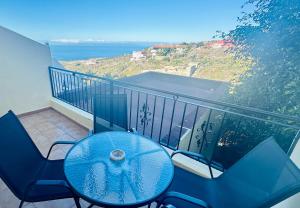 a balcony with a table and chairs and the ocean at Apartamentos Ajabo Adeje in Adeje