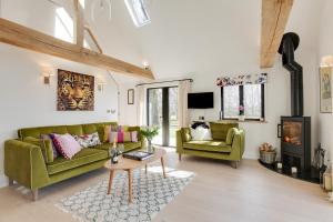 a living room with a green couch and a table at Little Larks Barn in Felsted Station