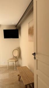 a room with a chair and a tv on the wall at La Césarine in Nyons