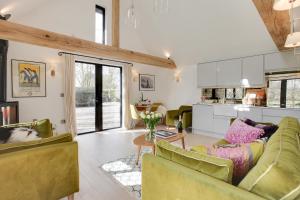 a living room with two couches and a kitchen at Little Larks Barn in Felsted Station