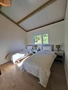 two beds in a room with a window at Countryside Cabin in Charlestown