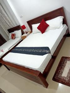 a bedroom with two beds with white and red pillows at Rian Rest in Dehiwala