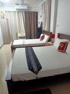 a hotel room with two beds and a window at Rian Rest in Dehiwala
