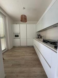 a kitchen with white cabinets and a large window at Luxury Villa Mariachiara in Monopoli