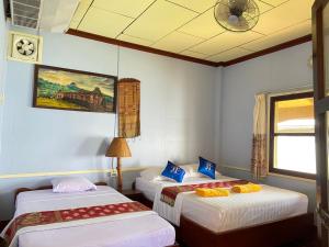 a room with two beds and a ceiling at Anouxa Riverview Guesthouse in Champasak