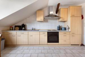 a kitchen with wooden cabinets and a stove at Ferienwohnung Thomée - Ruhig gelegen, ideal für Monteure und Erholungssuchende in Looft
