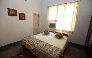 a bedroom with a bed with two pillows and a window at Chaudhary dharamshala in Jāmb