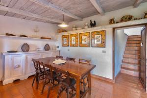 a dining room with a wooden table and chairs at Porto Ercole Prestige Villa in Cala Galera +32 photos