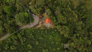 an aerial view of a red barn in the middle of a forest at Kamalú Glamping in Medellín