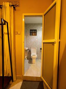 an open door to a bathroom with a toilet at Msafiri Haven in Moshi +5 photos