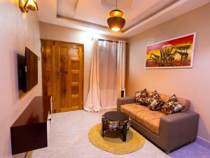 a living room with a couch and a tv at Msafiri Haven in Moshi