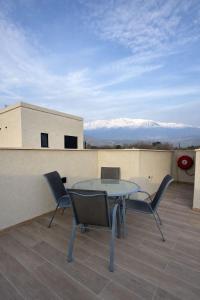 a table and chairs on a balcony with snow covered mountains at נופי דפנה in Dafna