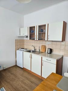 a kitchen with white cabinets and a sink at Apartmán pro dvě osoby Ostrov in Ostrov