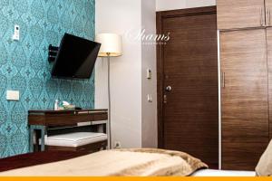 a bedroom with a desk and a tv on the wall at Shams Albasra Hotel in Al Başrah