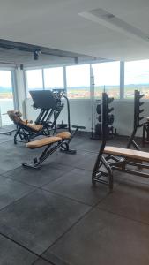ein Fitnessstudio mit Stühlen und einer Bank in einem Raum in der Unterkunft Studio Design 310 in Sobral